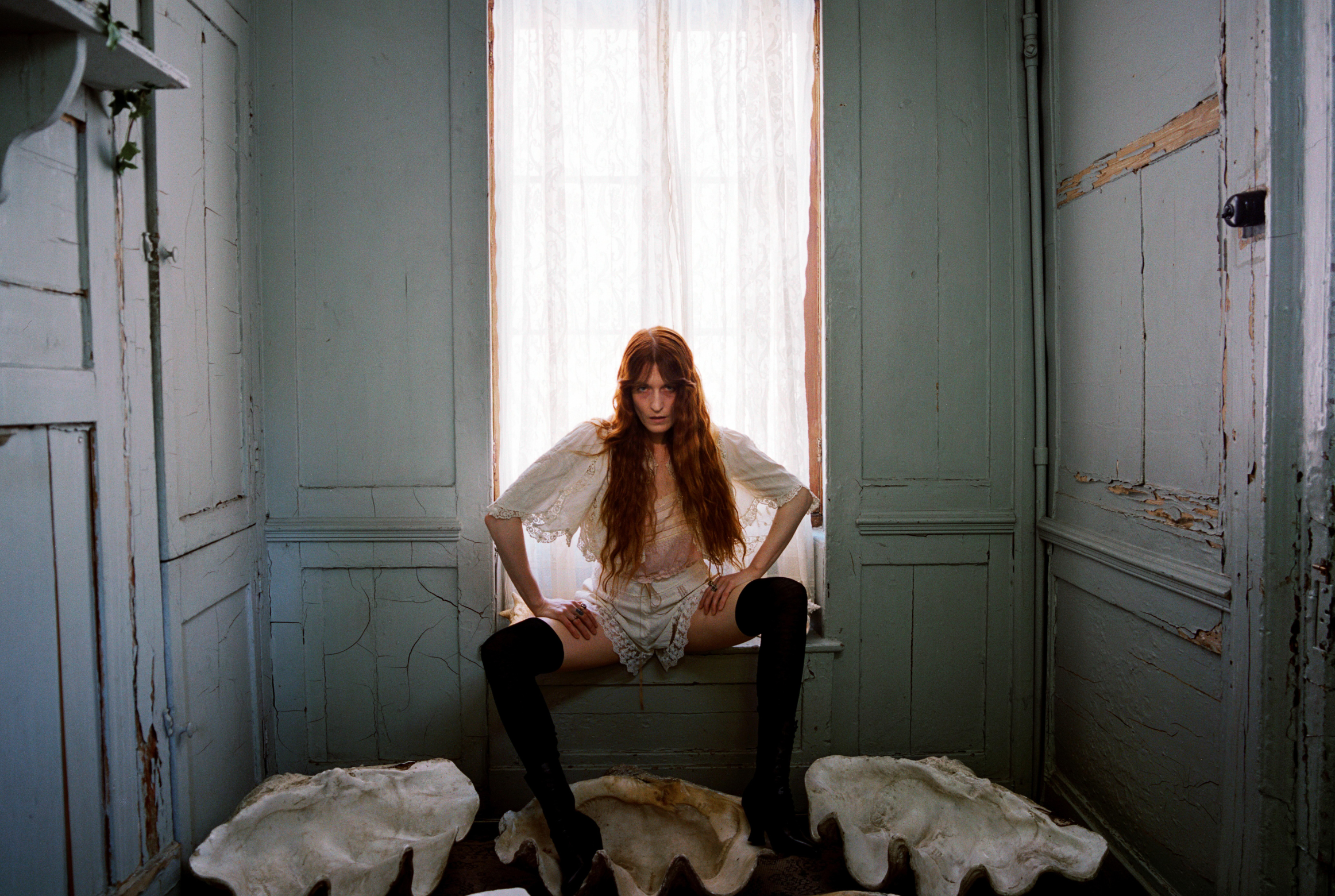 Florence from Florence + the Machine sitting on a window edge.